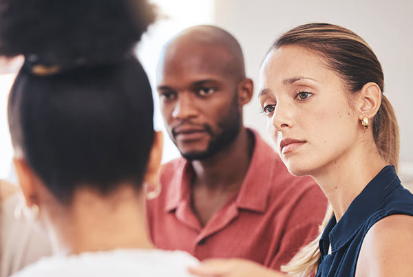 Couple en discussion avec une interlocutrice, en lien avec la planification de préarrangements funéraires.